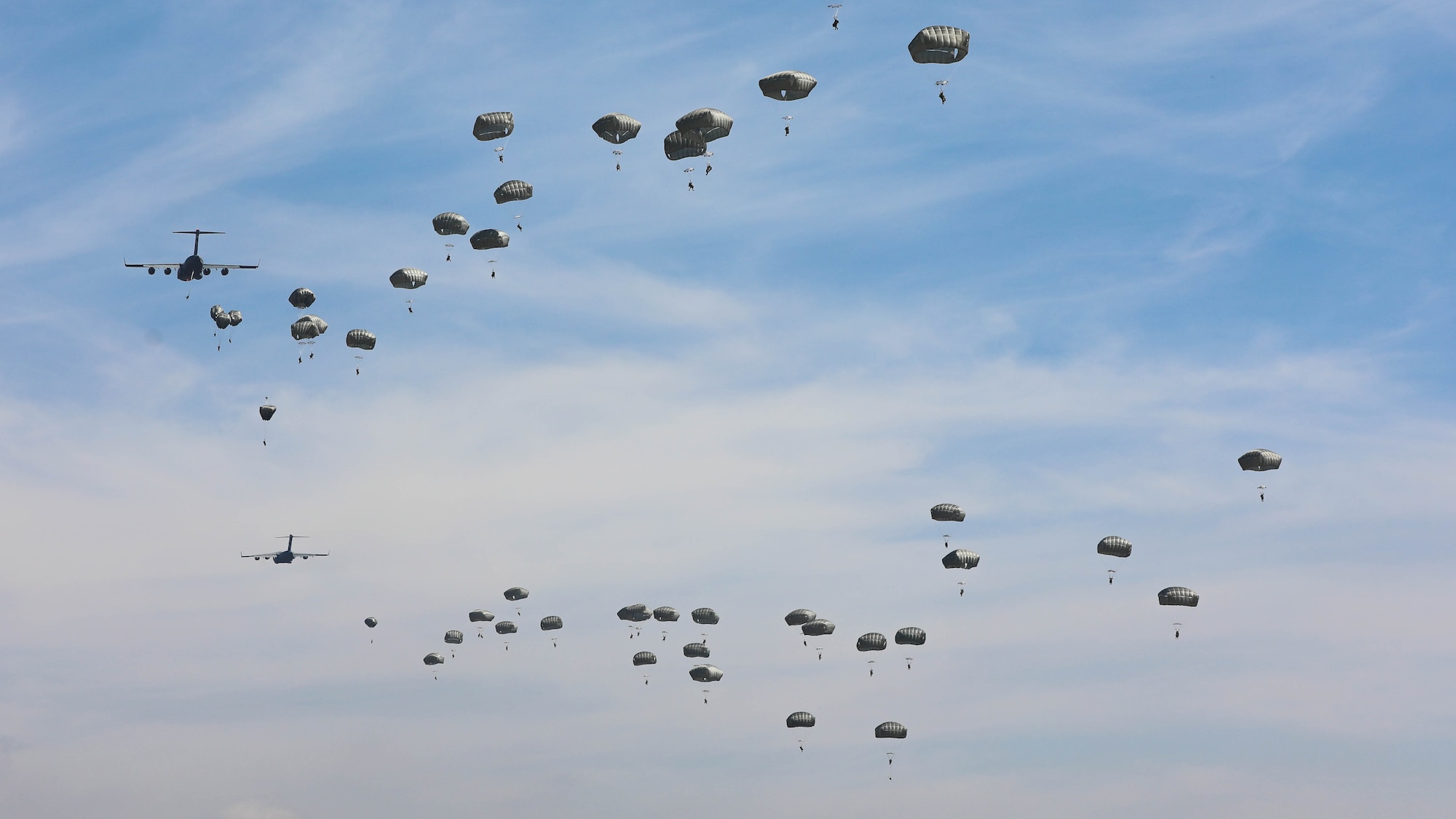Soldiers parachute out of an C-17 Globemaster III aircraft during an training exercise.