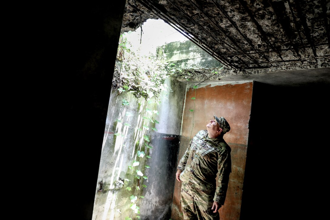 Capt. Florian Waitl, the Wisconsin Army National Guard command historian, inspects a World War II fighting position March 19 during a recent visit to Papua New Guinea. He was among 40 Wisconsin National Guard Airmen and Soldiers to spend the week of March 17-22 in Papua New Guinea collaborating with and training alongside the Papua New Guinea Defence Force as part of the State Partnership Program. This current exchange includes meetings between leadership along with training in instruction, medical, security forces, and collaboration with senior non-commissioned officers. The Wisconsin National Guard and Papua New Guinea began their partnership in 2020 and have since had several key leader engagements and site visits to strengthen that relationship. Wisconsin National Guard photo by Staff Sgt. Kati Volkman