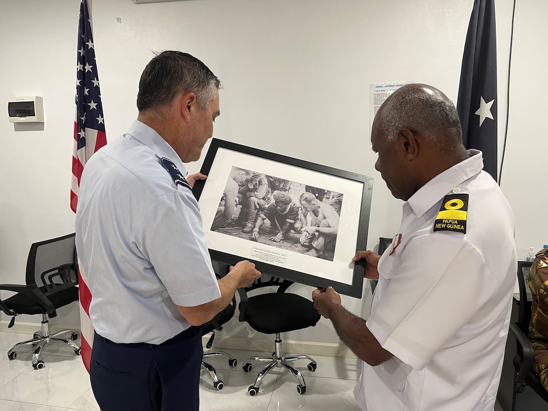 Maj. Gen. Paul Knapp, Wisconsin’s adjutant general, presents Commodore Philip Polewara, acting defence chief of the Papua New Guinea Defence Force, with a framed print March 18 of an interaction between Soldiers of the 32nd Division and a Papua New Guinean sketching a diagram of Japanese military positions from Nov. 15, 1942 during the campaign to drive the Japanese army out of Buna. The 32nd Division was largely composed of Wisconsin National Guard Soldiers when World War II began. The photo underscores how far back Wisconsin’s history goes with Papua New Guinea. Forty Wisconsin National Guard Airmen and Soldiers spent the week of March 17-22 in Papua New Guinea collaborating with and training alongside the Papua New Guinea Defence Force as part of the State Partnership Program. This current exchange includes meetings between leadership along with training in instruction, medical, security forces, and collaboration with senior non-commissioned officers. The Wisconsin National Guard and Papua New Guinea began their partnership in 2020 and have since had several key leader engagements and site visits to strengthen that relationship. Wisconsin National Guard photo by Staff Sgt. Kati Volkman