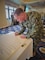 Installation Commanding Officer Capt. Henry Roenke signs the Sexual Assault Awareness and Prevention Month Proclamation during a tenant command meeting at the Officers' Club on Apr. 4, 2024.
