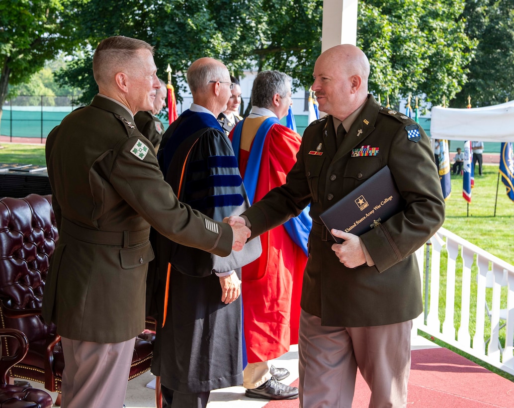 Chap. (Lt. Col.) Raymond Leach (right), deputy command chaplain and regional chaplain personnel manager for the U.S. Army Reserve’s 99th Readiness Division, receives his diploma during the U.S. Army War College graduation ceremony July 28, 2023, at Carlisle Barracks, Pennsylvania. “Since the Army’s work today is so very diverse and often is focused on providing human care and support across the globe, Chaplains are essential personnel at every level and in every mission,” Leach said. (Photo credit: U.S. Army War College)
