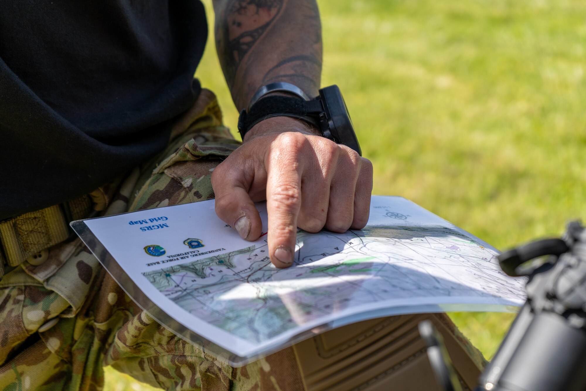 A person in uniform points to a map.