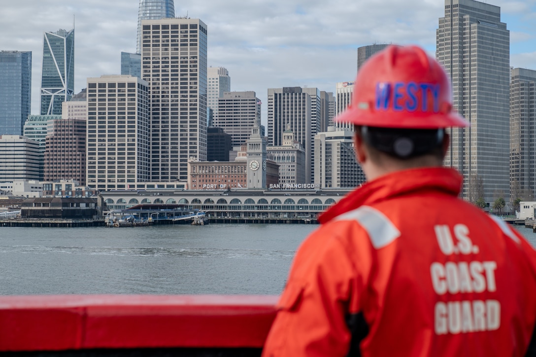 U.S. Coast Guard Petty Officer 1st Class John Westbrook, a damage controlman aboard the Coast Guard Cutter Polar Star (WAGB 10), looks out at the San Francisco ferry building as the Polar Star transits the San Francisco Bay upon the cutter's return to the United States following the completion of Operation Deep Freeze 2024, March 31, 2024. Operation Deep Freeze is the annual logistical support mission provided by the Department of Defense to the National Science Foundation, managed by the U.S. Antarctic Program. (U.S. Coast Guard photo by Petty Officer 2nd Class Ryan Graves)