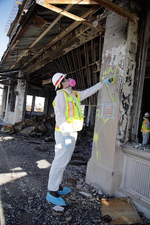 William Wierda, a historic architect from Technical Center of Expertise for the Preservation of Historic Structures, measures a column of a historic building on Maui, Jan. 18. The team from the Seattle District, U.S. Army Corps of Engineers assisted the Hawaii Wildfires Recovery Mission on a Federal Emergency Management Agency mission assigned task order to assess structures in the Lahaina National Historic Landmark District. The team was not required to wear the hoodies of their protective suits because of the low risk of contact with ash or debris while evaluating structures and buildings. Wierda is wearing a reflective vest but it was not required on this evaluation as there was no risk of vehicular traffic. The buildings were damaged in the August 8, 2023 wildfire on Maui. The buildings were damaged in the Aug. 8, 2023, wildfires on Maui.