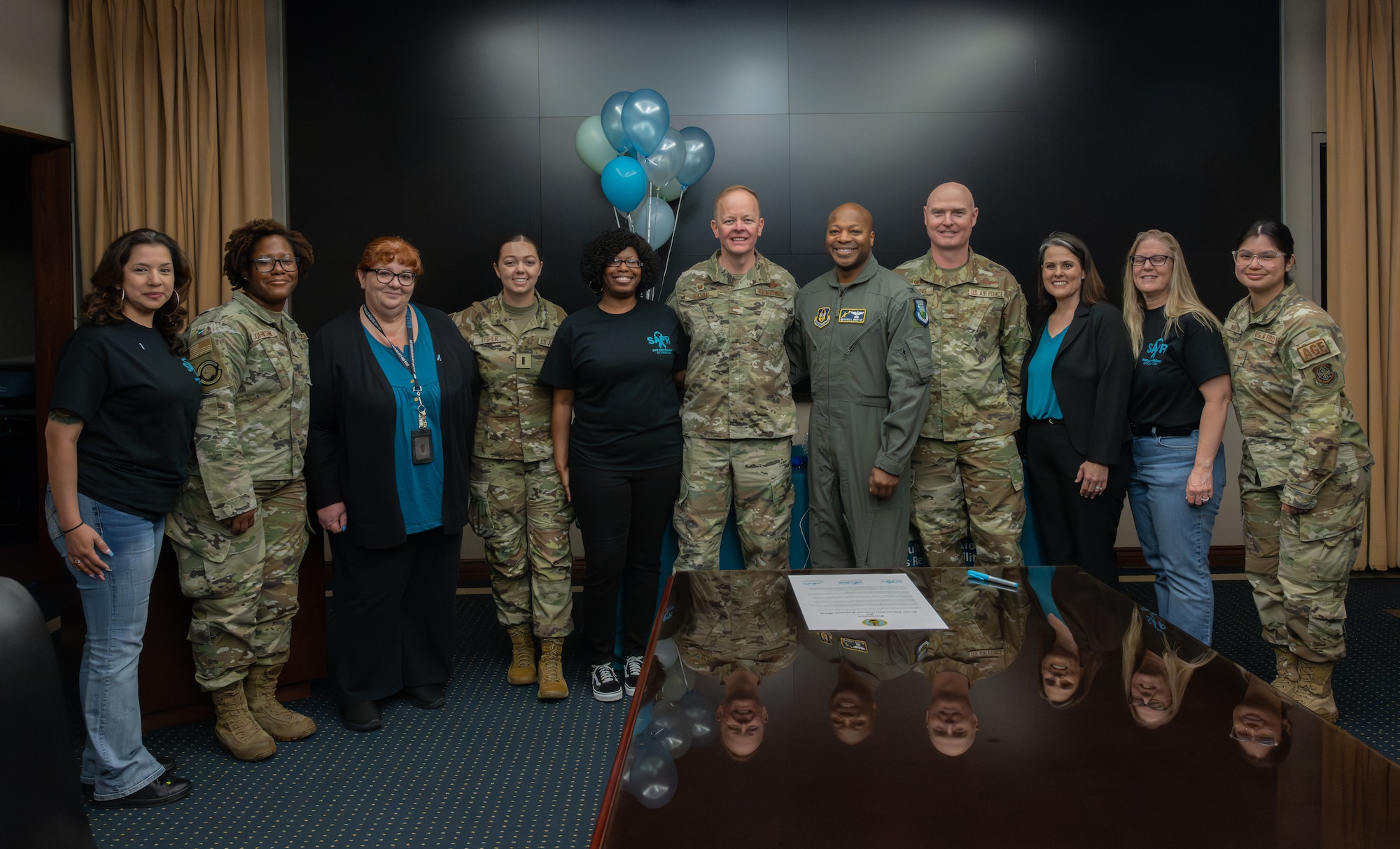 Sexual Assault Prevention office members pose with Travis leadership at the Sexual Assault Awareness and Prevention Month proclamation signing event.