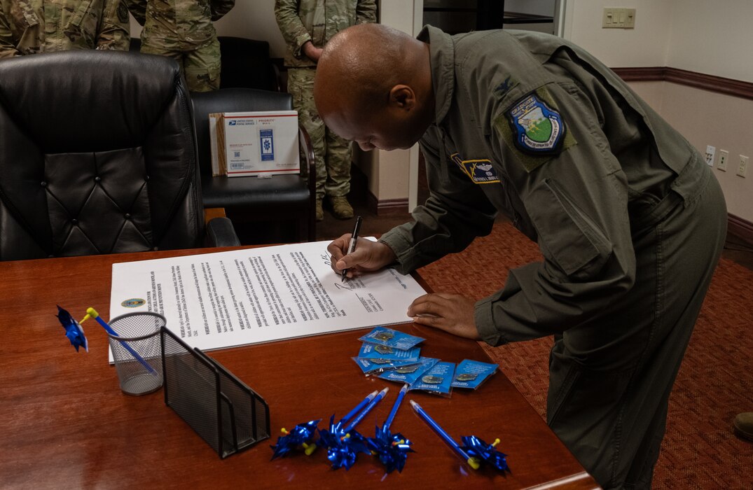 Col. Patrick Brady-Lee, 349th Air Mobility Wing commander, signs this year’s Month of the Military Child, Autism Awareness Month and Child Abuse Prevention Month proclamation