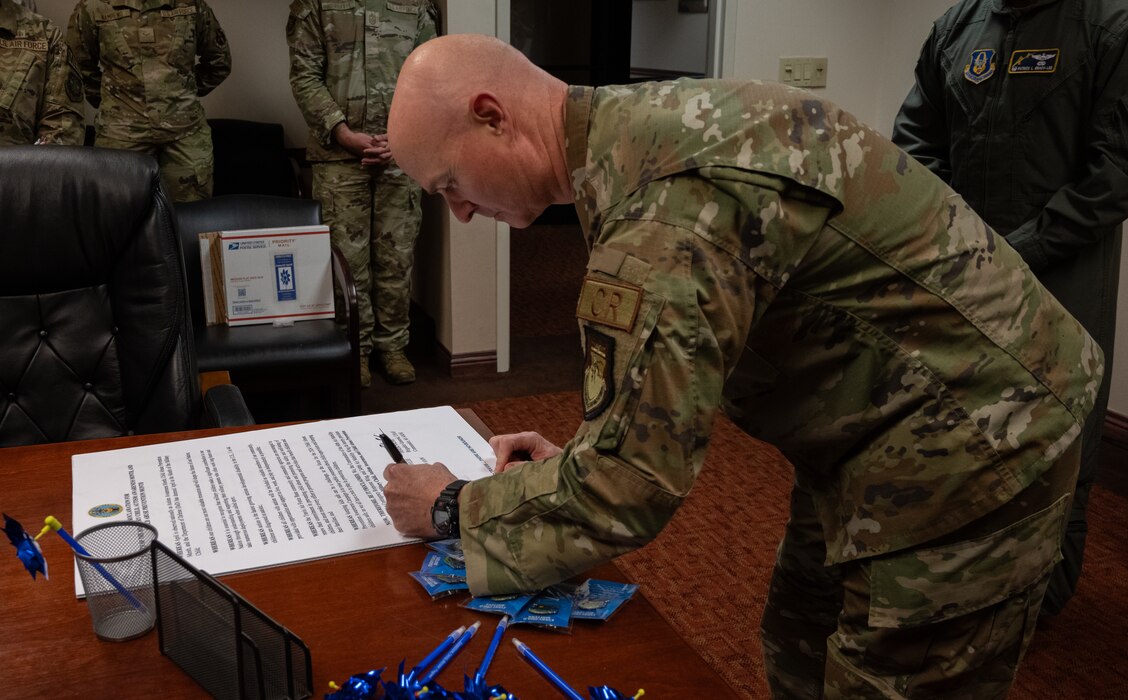 Col. Jason Herring, 621st Contingency Response Wing commander, signs this year’s Month of the Military Child, Autism Awareness Month and Child Abuse Prevention Month proclamation