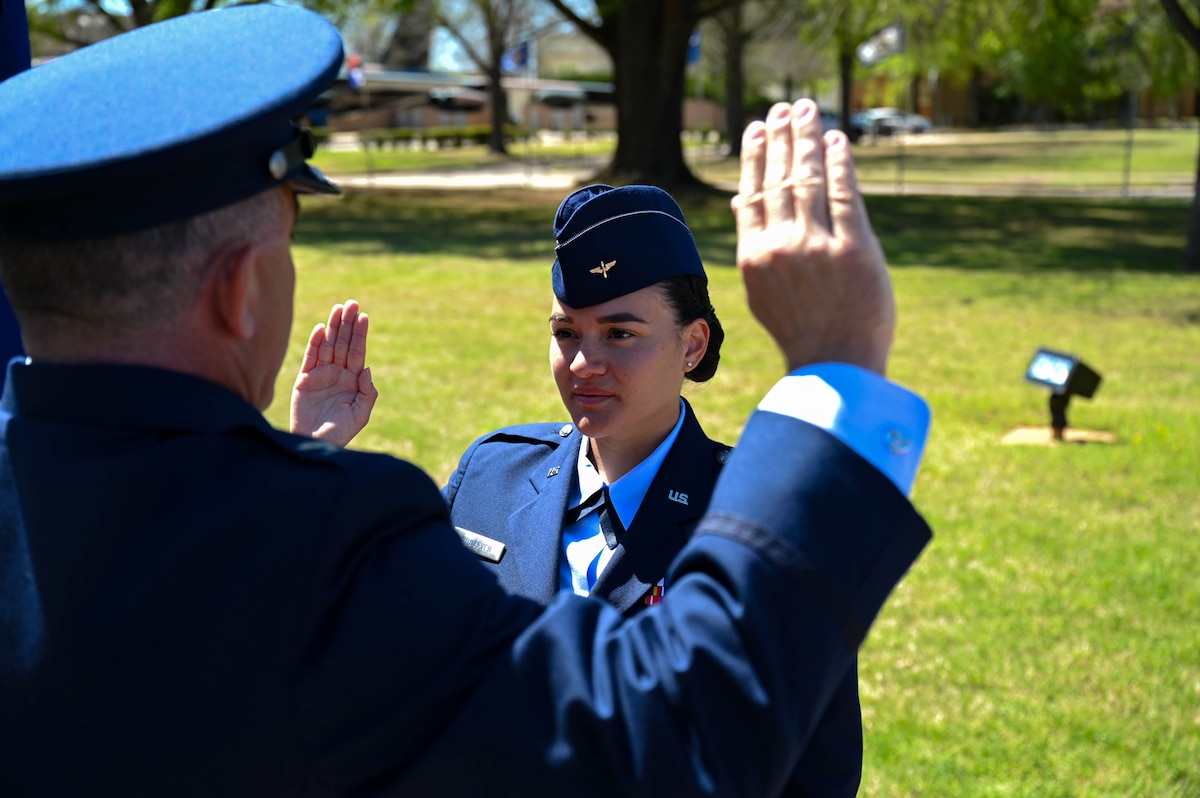 U.S. Air Force Col. Josh Koslov, 350th Spectrum Warfare Wing commander, left, administers the Oath of Office to U.S. Air Force 2nd Lt. Ericka Woolever, U.S. Air Force Officer Training School trainee, right, at Maxwell Air Force Base, AL, March 28, 2024. Woolever is the first member from the 350th SWW to attend OTS. (U.S. Air Force photo by Capt. Benjamin Aronson)