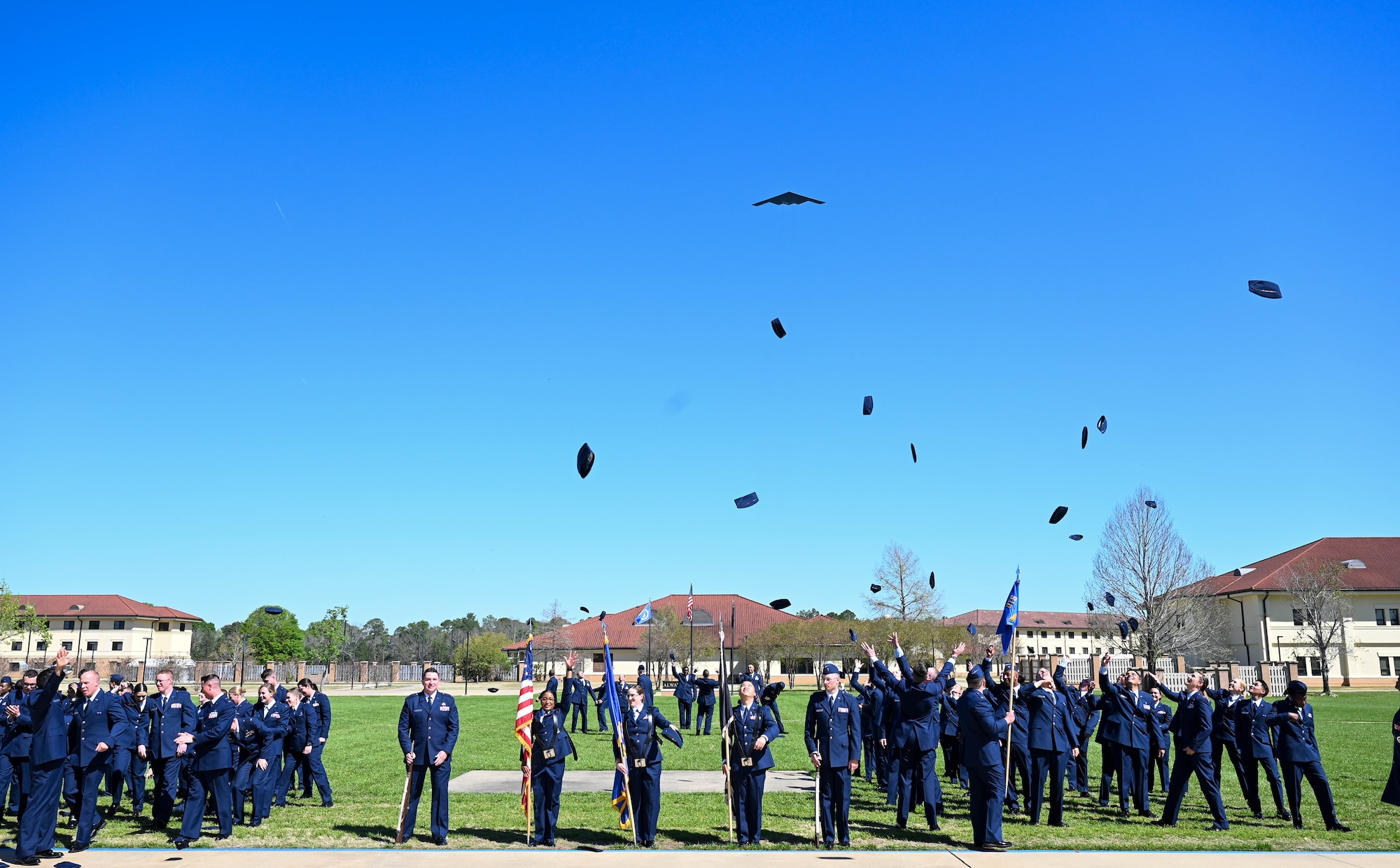 U.S. Air Force Officer Training School graduates throw their flight caps in the air upon graduating at the completion of the OTS graduation parade at Maxwell Air Force Base, AL, March 29, 2024. The program consists of 30 hours of pre-requisite distance learning and eight weeks of military training and leadership development for college graduates. (U.S. Air Force photo by Capt. Benjamin Aronson)