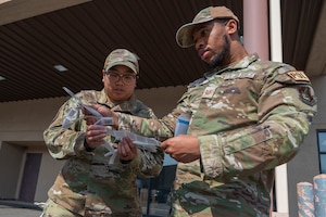 U.S. Air Force Tech. Sgt. Marilou Leybel, 51st Logistics Readiness Squadron fleet management and analysis, and Tech. Sgt. Charles Cotton, 51st Logistics Readiness Squadron noncommissioned officer in charge of the fuel service center, prepare a QR code to place on a vehicle at Osan Air Base, Republic of Korea, April 1, 2024. The 51st LRS vehicle management flight and the fuels management flight have worked closely to service government vehicles from many units across the 51st Fighter Wing, ensuring the readiness of the Airmen at Osan. (U.S. Air Force photo by Senior Airman Kaitlin Frazier)