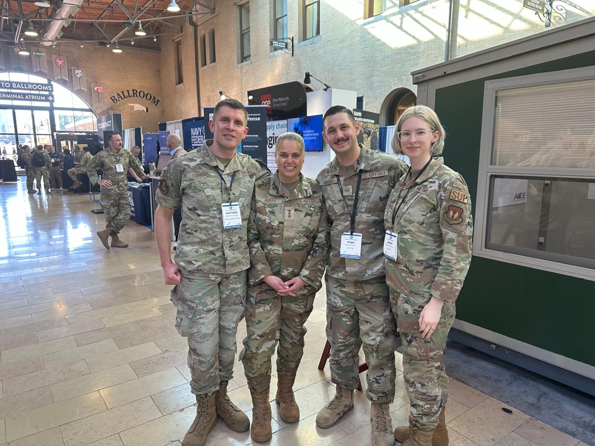 Four people in military uniforms pose for a picture