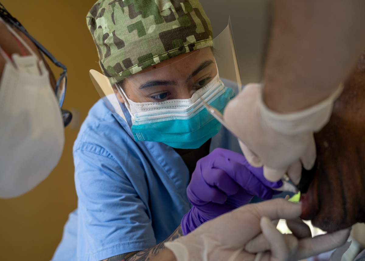 Image of an Airman treating a patient.