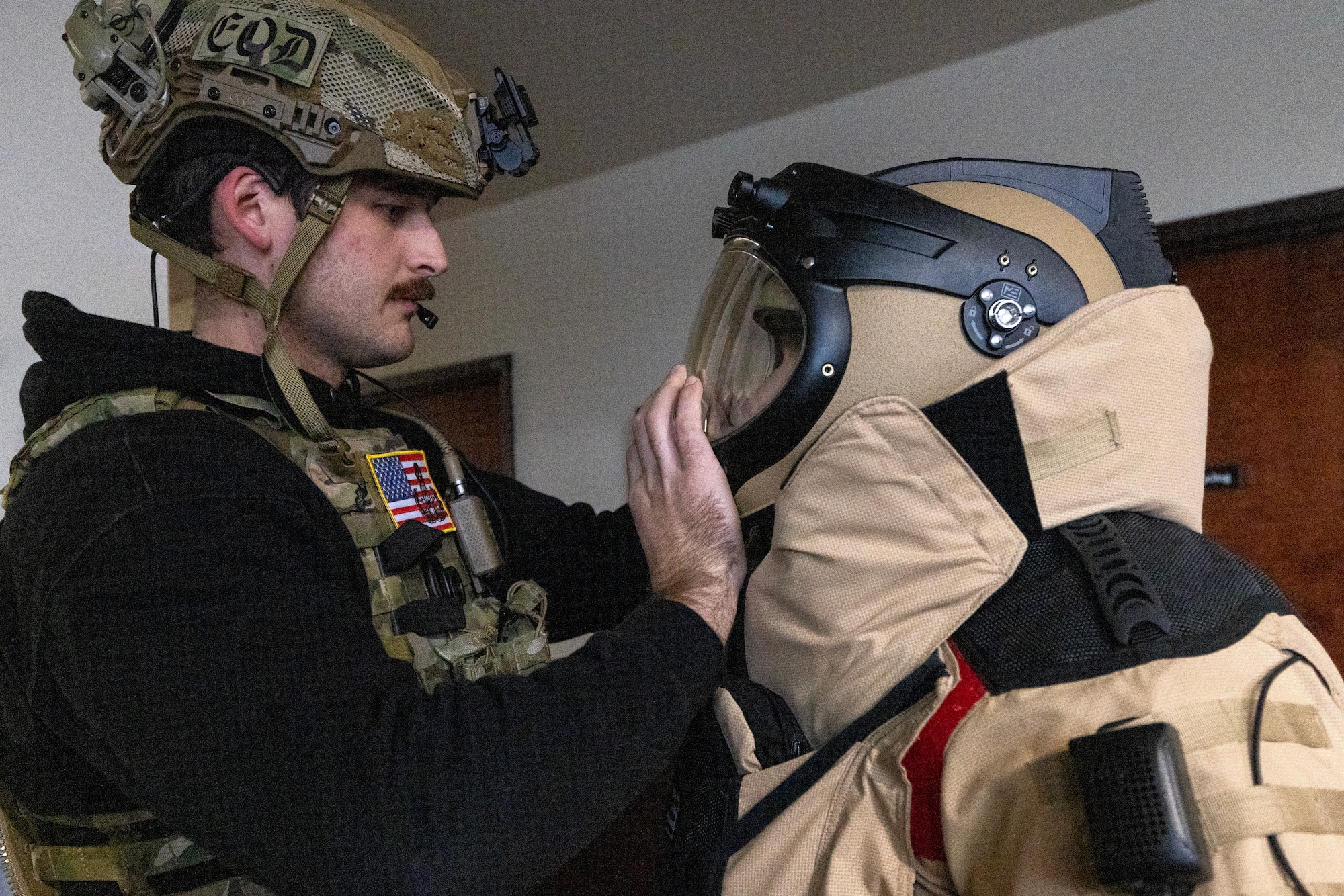 U.S. Air Force Airman 1st Class Robert Wittig, left, closes the helmet on Senior Airman Russell J. Bongiovanni’s EOD-10E bomb suit. The explosive ordnance disposal technicians with the 177th Fighter Wing, New Jersey Air National Guard, were participating in the Joint Chemical, Biological, Radiological, Nuclear, and High Yield Explosives Characterization, Exploitation, and Mitigation Course at the CURE Insurance Arena in Trenton, New Jersey, March 27, 2024.