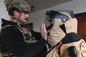 U.S. Air Force Airman 1st Class Robert Wittig, left, closes the helmet on Senior Airman Russell J. Bongiovanni’s EOD-10E bomb suit. The explosive ordnance disposal technicians with the 177th Fighter Wing, New Jersey Air National Guard, were participating in the Joint Chemical, Biological, Radiological, Nuclear, and High Yield Explosives Characterization, Exploitation, and Mitigation Course at the CURE Insurance Arena in Trenton, New Jersey, March 27, 2024.