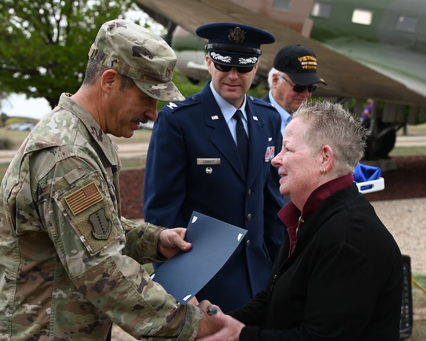 U.S. Air Force Col. Ian Rybczynski, 17th Medical Group commander, shakes hands with Cash Milroy, Army Vietnam War veteran, during the 2024 National Vietnam War Veteran Memorial and Pinning Ceremony at the Weyandt-Eddy Memorial Plaza, Norma Brown Headquarters building, Goodfellow Air Force Base, Texas, March 29, 2024. The Vietnam War Veteran commemorative lapel pin includes an eagle’s head representing courage, stripes representing the nation's flag and six stars representing the allies during the war.