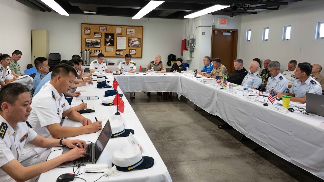 Members of the U.S. and Chinese military meet around a large table.