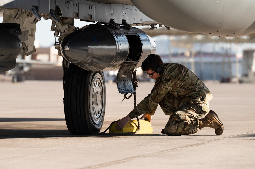 Senior Airman removes the chocks from an F-15E Strike Eagle