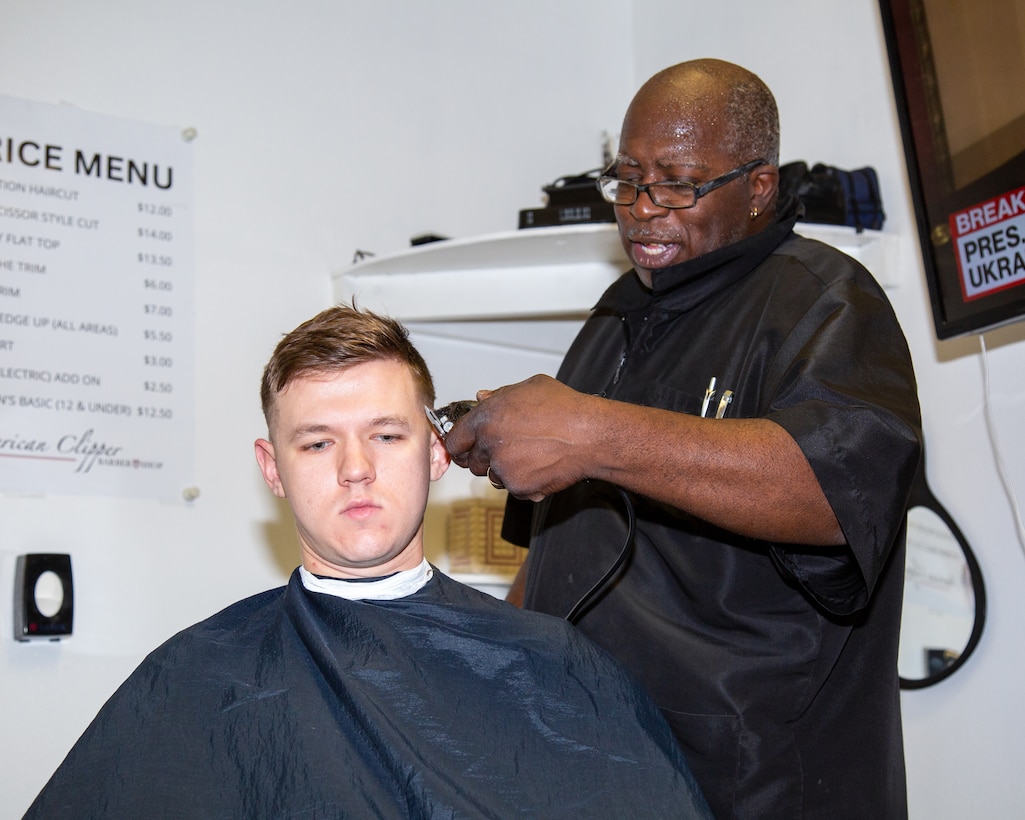 Phendell "Jay" Johnson, the base barber for Marine Corps Logistics Base Barstow, gives LCpl Chase Foree, military police, a haircut at the new, temporary barbershop at building 18 aboard MCLB Barstow, Feb. 27, 2024. Jay enjoys taking the moments he has with his customers to talk to them.