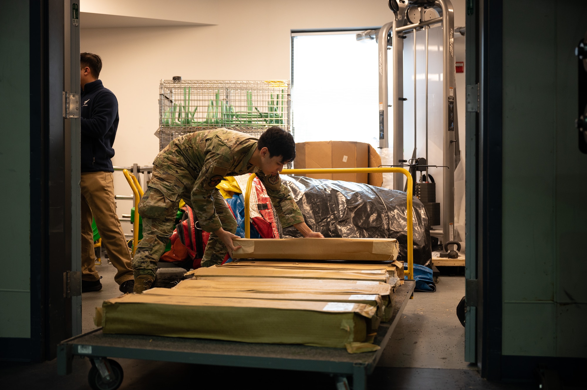 An Airman stacks cots on a cart during a beddown exercise.
