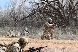 airmen survey the land with a rifle in hand