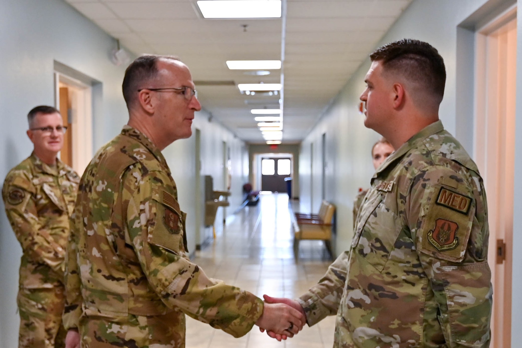 U.S. Air Force Lt. Gen. John Healy, left, chief of the Air Force Reserve (AFR) and commander of Air Force Reserve Command (AFRC), coins Staff Sgt. Austin Childs, 301st Medical Squadron unit health moniter at Naval Air Station Joint Reserve Base Fort Worth, Texas, April 2, 2024. (U.S. Air Force photo by Nije Hightower)