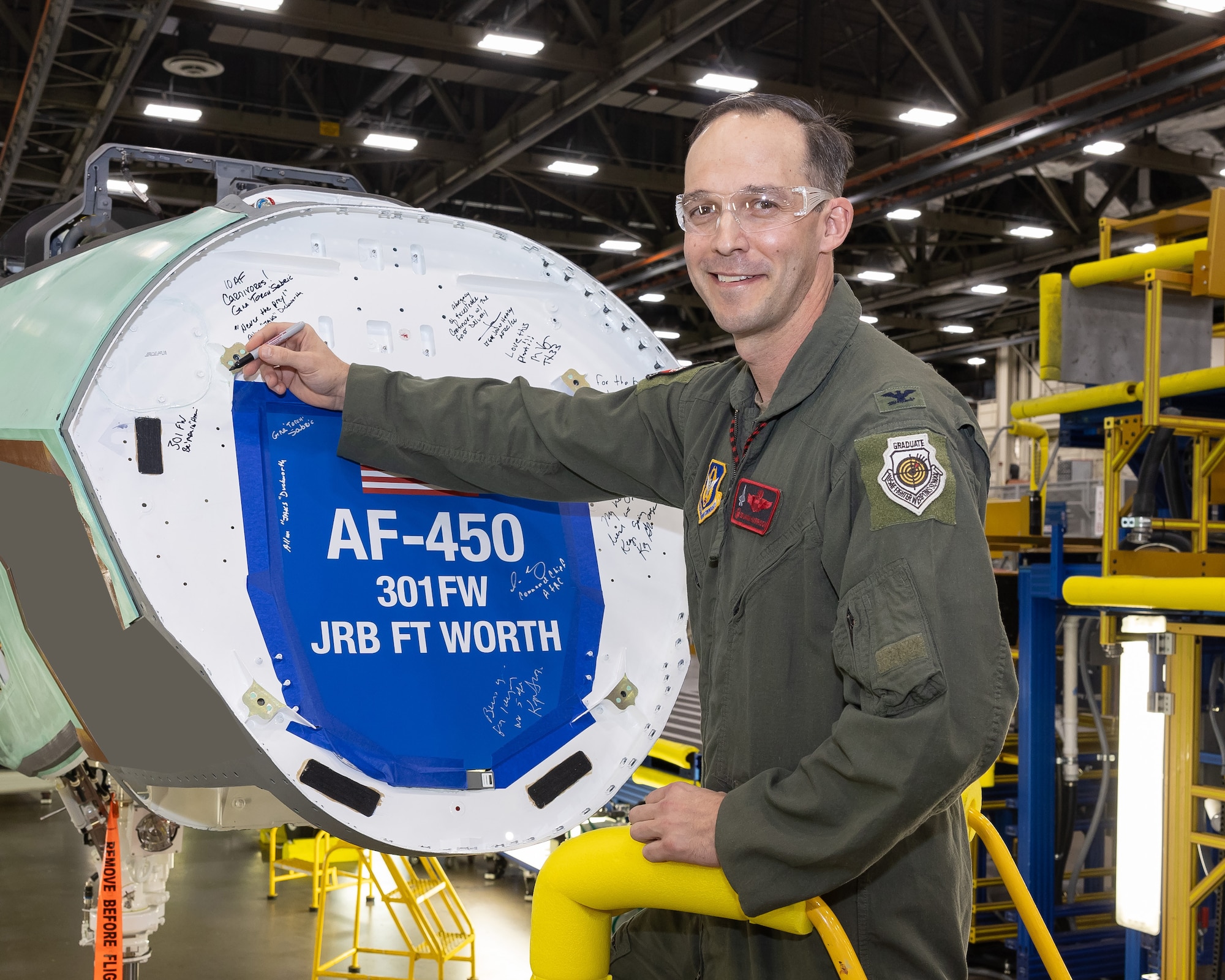 Col. Benjamin R. Harrison, Commander of the 301st Fighter Wing, etches a pivotal moment into the legacy of his wing, signing the bulkhead of the first F-35 Lightning II designated for the 301st. This symbolic gesture ushers in a new era of advanced combat readiness and technological prowess for the wing. (Photos courtesy of Lockheed Martin Aeronautics Company)