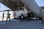 Members of the 233rd Space Group, Greeley Air National Guard Station, Greeley, Colorado load a mission support tractor/trailer onto a C-17 Globemaster courtesy of the 156th Airlift Squadron on April 10, 2023 at the 140th Wing, Buckley Space Force as part of annual exercise, Operation Global Thunder.