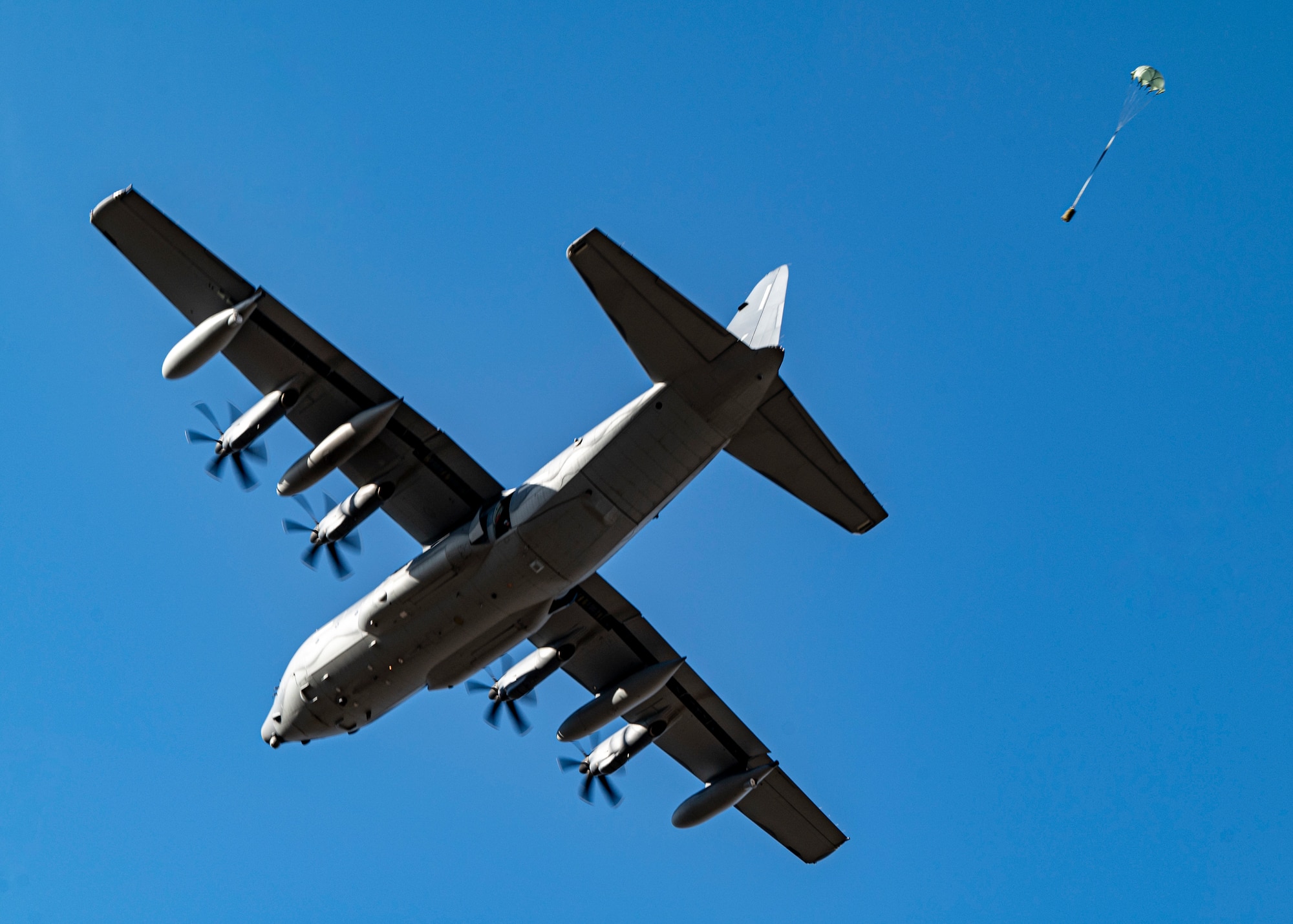 U.S. Air Force rescue Airmen drop cargo from an HC-130J Combat King II over Smoky Hill Air National Guard Range, Kansas, March 26, 2024. The cargo drops were part of the Rescue Rodeo, a rescue training event and competition. Each squadron participating in the event performed multiple precision drops over the range. (U.S. Air Force photo by Airman 1st Class Leonid Soubbotine)
