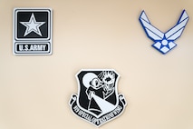3D-printed U.S. Army, 919th SOW, and Air Force emblems hang from a wall