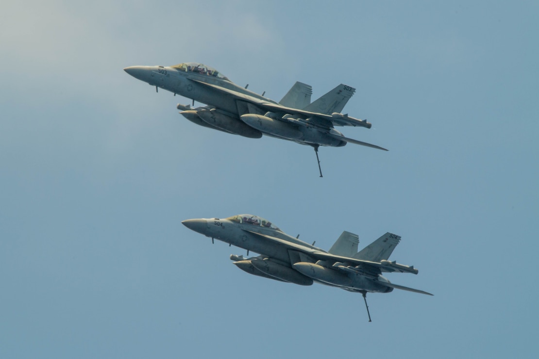 SOUTH CHINA SEA (March 27, 2024) A pair of EA-18G Growlers, assigned to the “Rooks” of Electronic Attack Squadron (VAQ) 137, fly above the Nimitz-class aircraft carrier USS Theodore Roosevelt (CVN 71), March 27, 2024. Theodore Roosevelt, flagship of Carrier Strike Group Nine, is underway conducting routine operations in the U.S. 7th Fleet area of operations. U.S. 7th Fleet is the U.S. Navy’s largest forward-deployed numbered fleet, and routinely interacts and operates with allies and partners in preserving a free and open Indo-Pacific region. (U.S. Navy photo by Mass Communication Specialist Seaman Apprentice Aaron Haro Gonzalez)