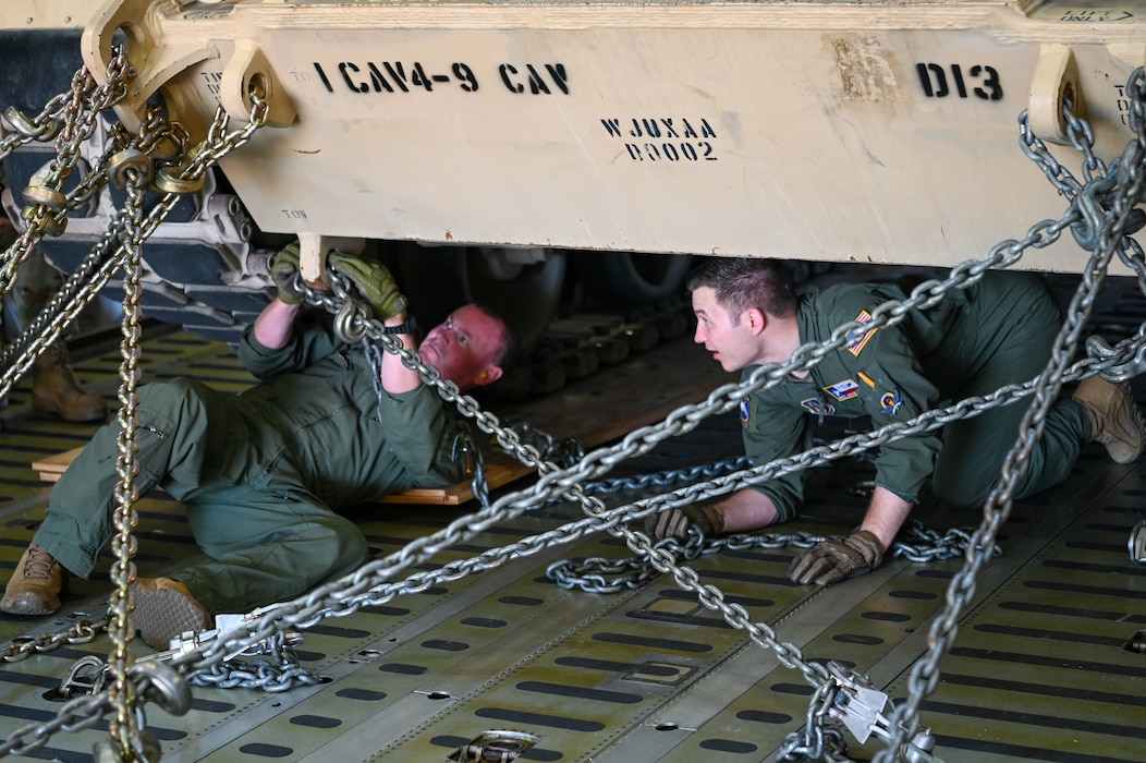 Tech Sgt. Cody Holsey (left) and Senior Master Sgt. John Krueger (right), 68th Airlift Squadron loadmasters, use chains to secure an M1A2 Abrams Main Battle Tank aboard a 433rd Airlift Wing C-5M Super Galaxy at Robert Gray Army Airfield, Fort Cavazos, Texas on April 4th, 2024.