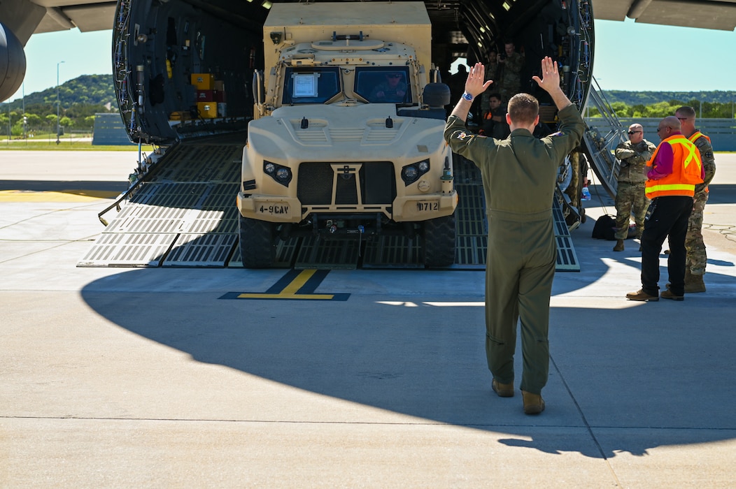 Senior Master Sgt. John Krueger, a 68th Airlift Squadron loadmaster, guides a Soldier driving a Joint Light Tactical Vehicle aboard a 433rd Airlift Wing C-5M Super Galaxy at Robert Gray Army Airfield, Fort Cavazos, Texas on April 4th, 2024.