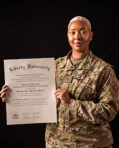 U.S. Air Force Tech. Sgt. Brandy Preston, 56th Operational Support Squadron aircrew flight equipment lead trainer, showcases her doctorate of community care and counseling, March 8, 2024, at Luke Air Force Base, Arizona.