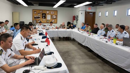 Members of the U.S. and Chinese military meet around a large table.