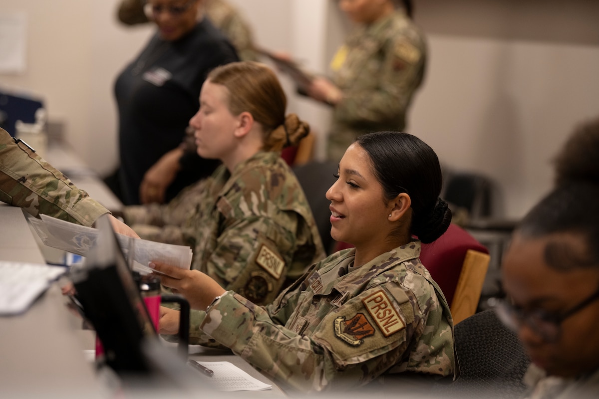 U.S. Air Force Senior Airman Viviana Capacete, 23rd Force Support Squadron personnel readiness technician, processes Airmen through a personnel deployment function line