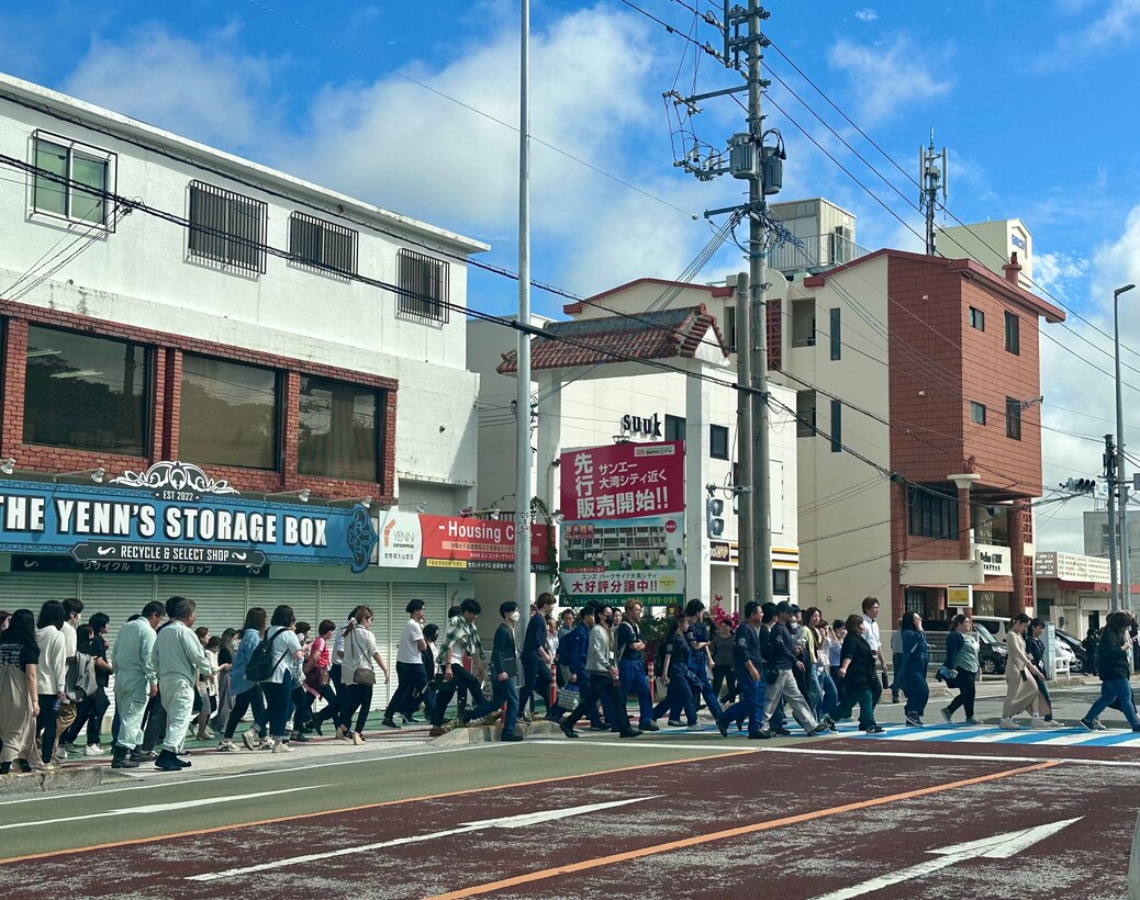 Local Okinawa residents from Ginowan City cross the National Route 58 highway toward Marine Corps Air Station Futenma during a tsunami evacuation in Okinawa, Japan, April 3, 2024. Through Local Implementation Agreements, Marine Corps Installations Pacific and local Okinawa municipalities allow Okinawa residents to gain on-base access to evacuate from lower elevations during a tsunami emergency event. By utilizing the routes through the base, residents can reach their destinations faster. (Courtesy photo by Marine Corps Air Station Futenma)