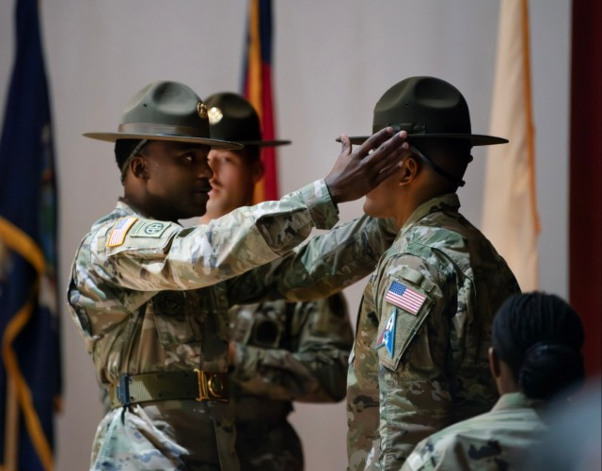U.S. Army Sgt. 1st Class Sytoi K. Warren, senior drill sergeant leader, adjusts the drill sergeant hat of Sgt. Yugi R. Moore, during a graduation ceremony at the U.S. Army Drill Sergeant Academy in Fort Jackson, S.C., April 3, 2024. Moore was one of first Guardians to graduate from the academy. (U.S. Army photo by Robert Timmons)