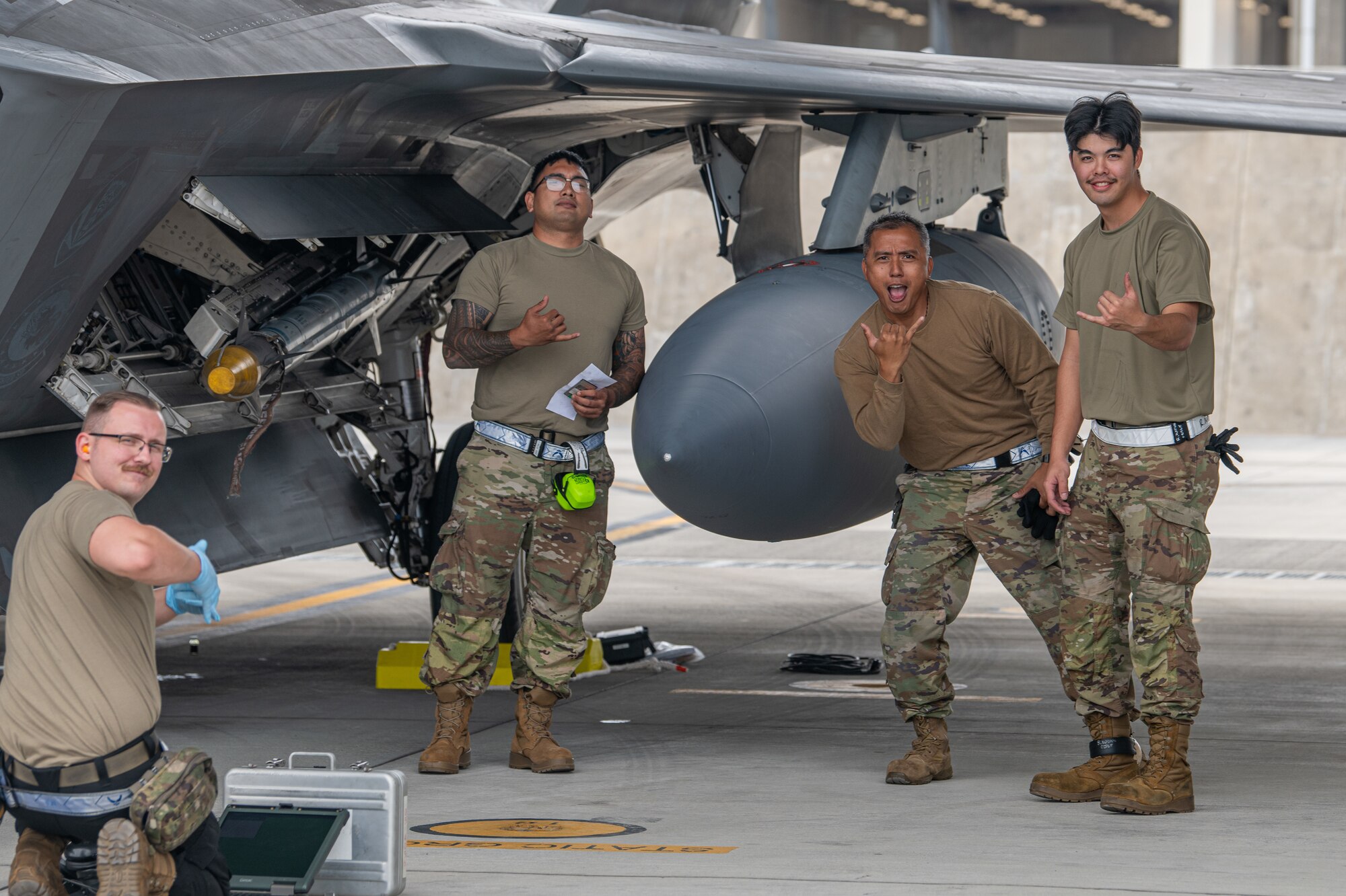U.S. Air Force Airmen assigned to the 19th and 199th Aircraft Maintenance Units pose for a photo during post-flight checks on an F-22A Raptor operated by 199th and 19th Fighter Squadrons at Kadena Air Base.