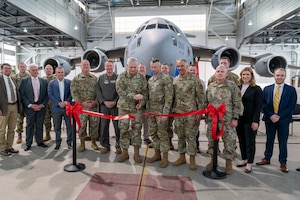 U.S. Army Maj. Gen. William Crane,  West Virginia National Guard Adjutant General, ceremoniously cuts a ribbon to mark the reopening of Hangar 305, Shepherd Field, Martinsburg, West Virginia, April 5, 2024. Attendees included local, state and federal representatives and staff, West Virginia National Guard leadership and 167th AW Airmen. A renovation project to remedy the Hangar 305’s foundation issues was completed in February 2024, allowing 167th Maintenance Group personnel to resume aircraft fuel cell maintenance in the facility. (U.S. Air National Guard photo by SMSgt Emily Beightol Deyerle)