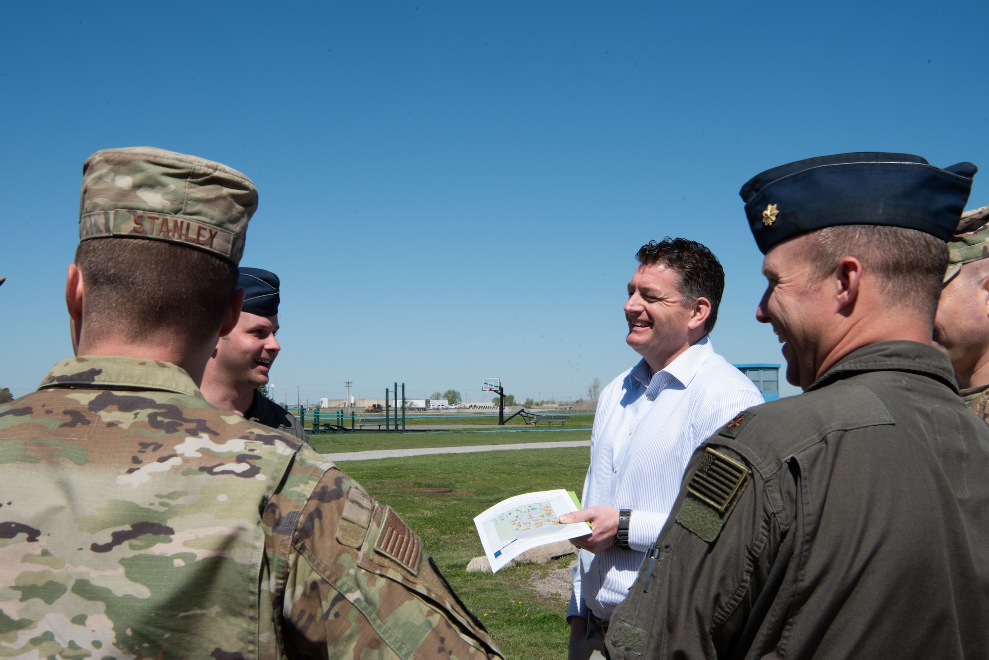 The Assistant Secretary of Defense for Special Operations and Low Intensity Conflict tours the 137 Special Operations Wing in business attire while talking with Airmen in OCPs