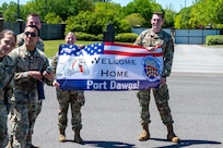 A photo of two Airmen holding a welcome home sign.