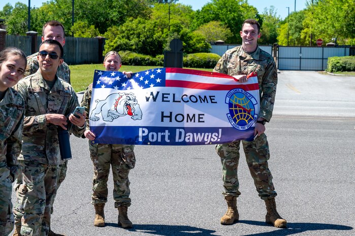 A photo of two Airmen holding a welcome home sign.