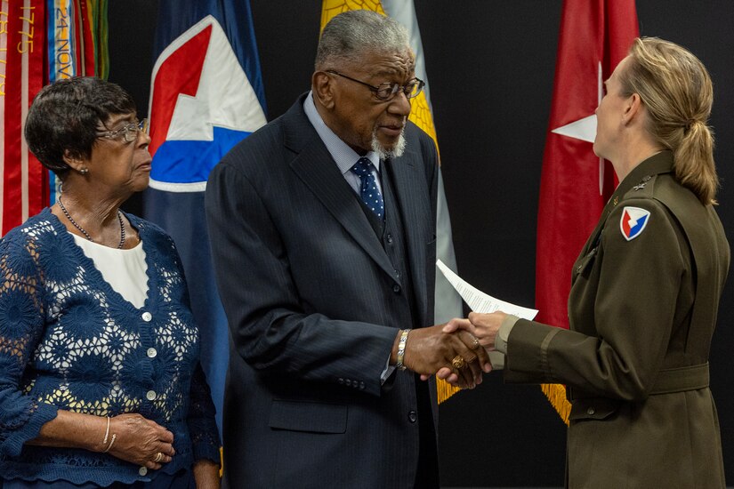 Brig. Gen. Paige M. Jennings, U.S. Army Financial Management Command commanding general, presents a one-star note to retired U.S. Army Command Sgt. Maj. Samuel McKoy, as his wife, Maxine, looks on during USAFMCOM’s Vietnam War commemoration at the Maj. Gen. Emmett J. Bean Federal Center in Indianapolis March 25, 2024. McKoy enlisted in December 1969 as a field artillery cannoneer, served as a finance specialist on his first tour in Vietnam, served with Army special forces on his second tour in Vietnam, and graduated with Class 15 of the U.S. Army Sergeant Major Academy in 1980. (U.S. Army photo by Mark R. W. Orders-Woempner)