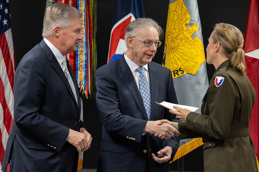 Brig. Gen. Paige M. Jennings, U.S. Army Financial Management Command commanding general, presents a one-star note to retired U.S. Army Lt. Col. (Dr.) Richard Storm, as Stan Soderstrom, the civilian aide to the Secretary of the Army for Indiana, prepares to give him a Vietnam War lapel pin during USAFMCOM’s Vietnam War commemoration at the Maj. Gen. Emmett J. Bean Federal Center in Indianapolis March 25, 2024. Storm enlisted in the U.S. Army in 1966 as a communications maintenance specialist, attended Officer Candidate School in 1967 and flight school in 1968, flew CH-47 Chinook helicopters with the 1st Cavalry Division in Vietnam from 1969-1970, became a dermatologist, and retired from the Army in 1992. (U.S. Army photo by Mark R. W. Orders-Woempner)
