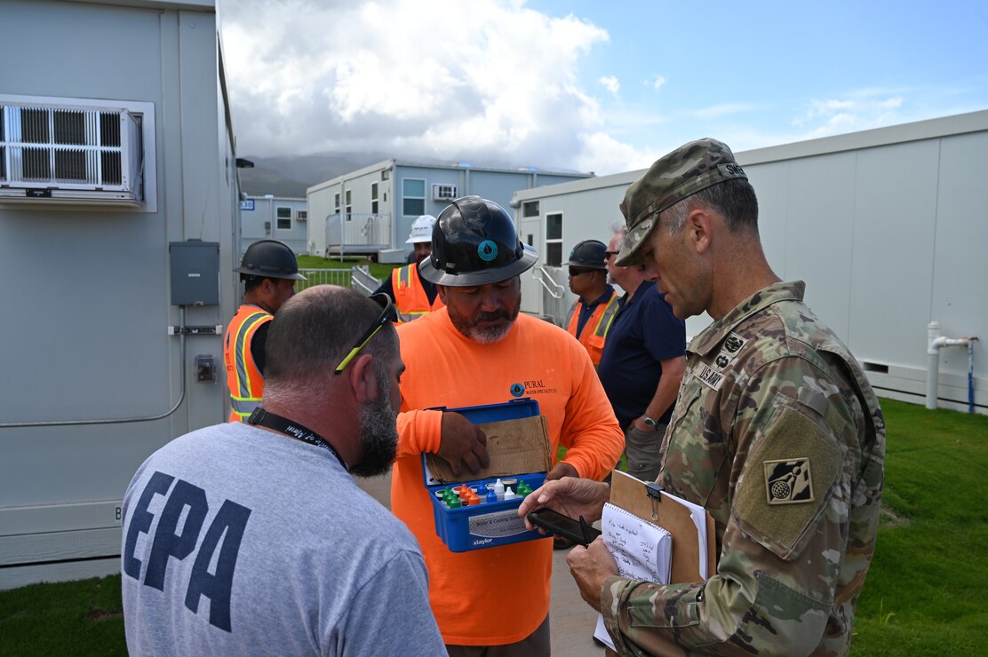 Government officials discuss water quality testing.