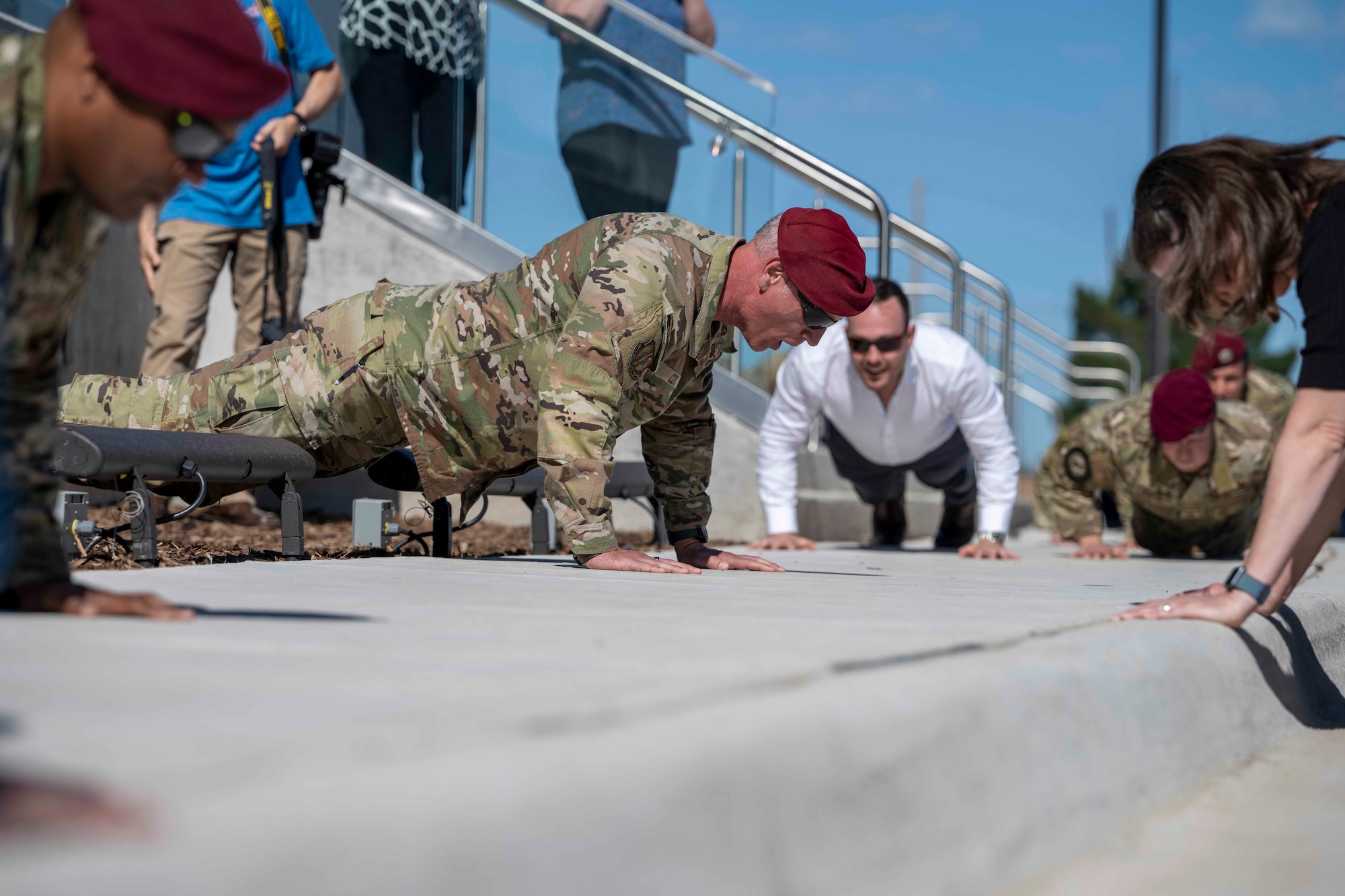 A man conducting push-ups while calling out commands for the crowd to follow.