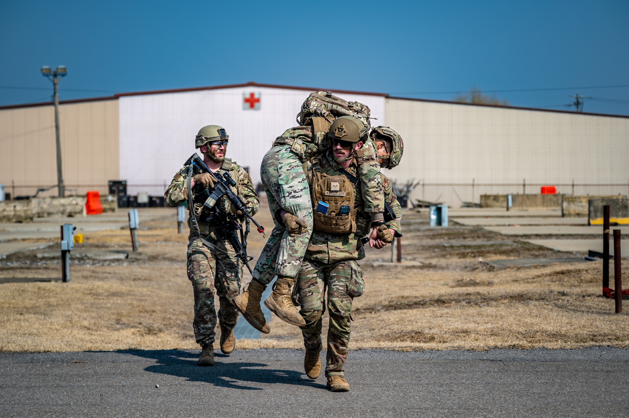 U.S. Air Force Senior Airman Ethan McGregor, 51st Logistics Readiness Squadron aircraft parts store journeyman, carries a simulated wounded Airmen to safety during a Combat Readiness Course at Osan Air Base, Republic of Korea, March 14, 2024. By extending beyond the 51 Security Forces Squadron to include Airmen from diverse career fields, the CRC builds a comprehensive defense framework for Osan AB. (U.S. Air Force photo by Staff Sgt. Thomas Sjoberg)