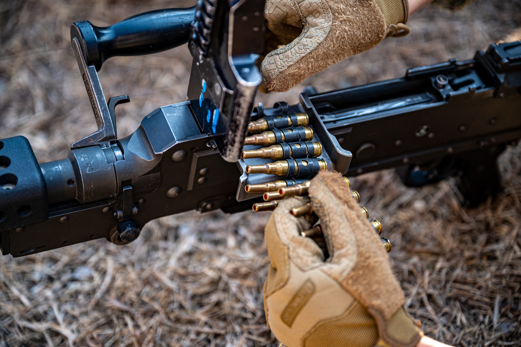 U.S. Air Force Airman Ka Youn, 51st Security Forces Squadron Defender, loads an M240 with training ammunition during a Combat Readiness Course at Osan Air Base, Republic of Korea, March 14, 2024. The CRC focuses on advanced combat tactics and life saving skills to develop multi-capable Airmen throughout Osan AB. (U.S. Air Force photo by Staff Sgt. Thomas Sjoberg)