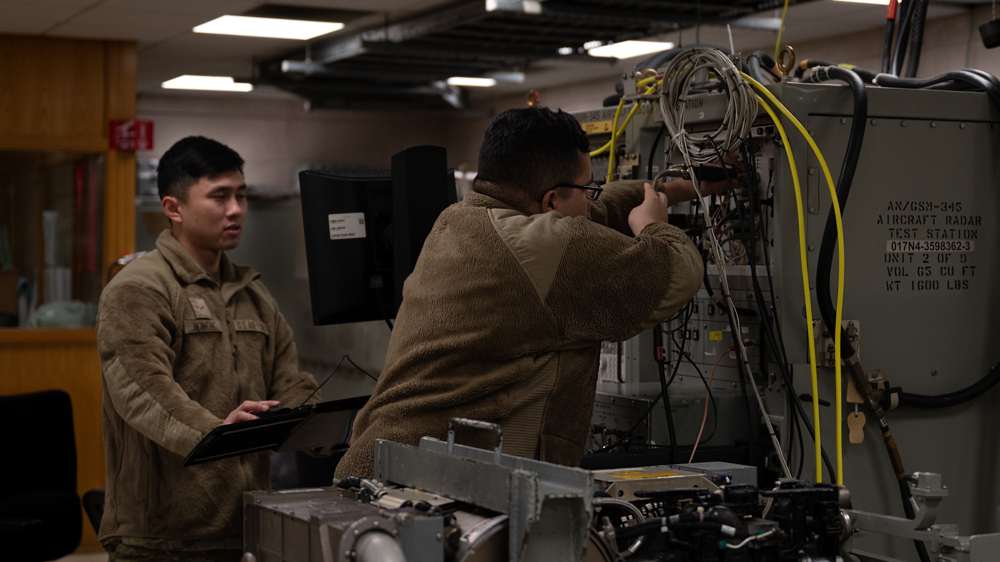 Two Airmen perform checks and maintenance on the last Enhanced Aircraft Radar test Station.