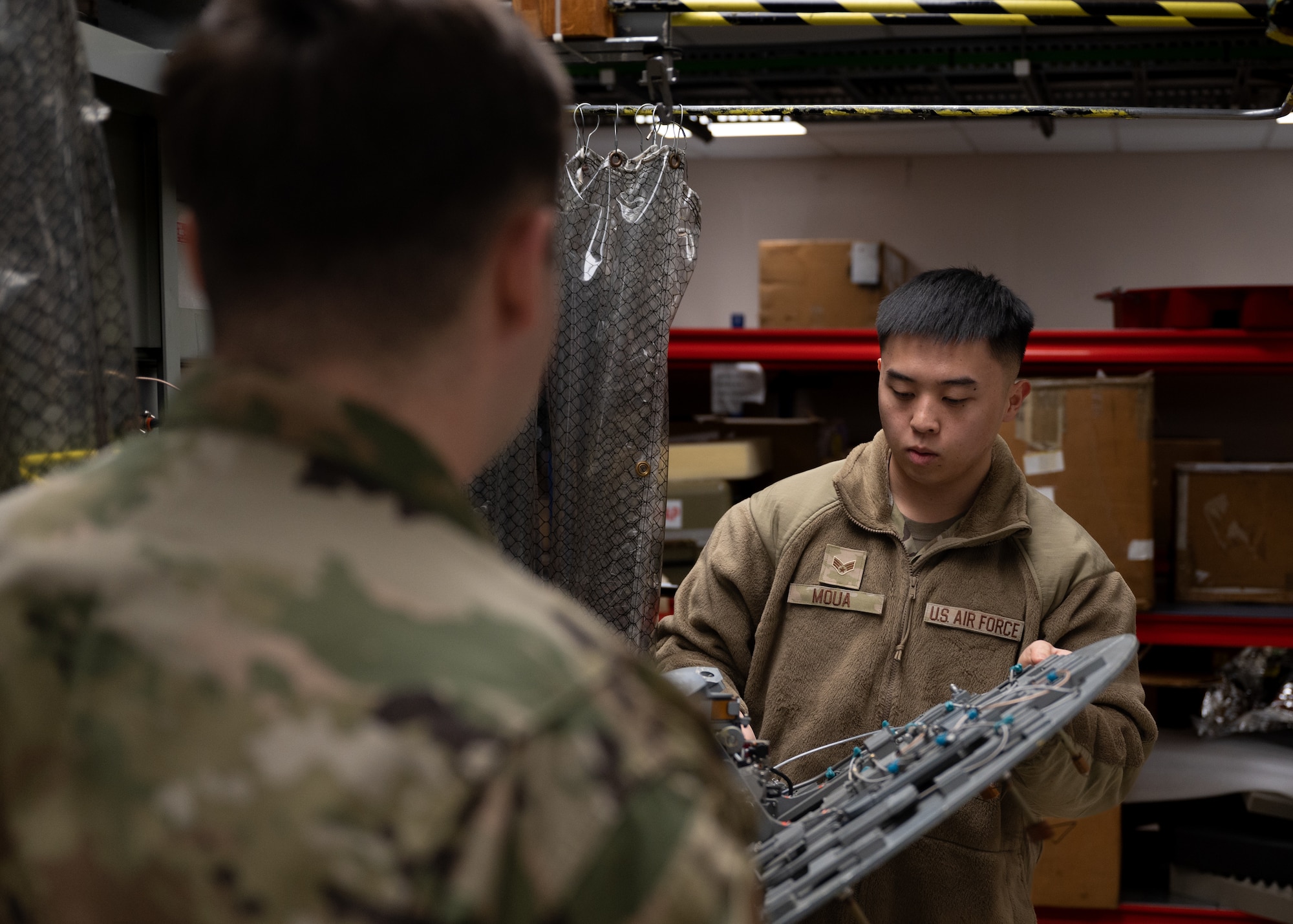 Two Airmen perform final maintenance checks on the